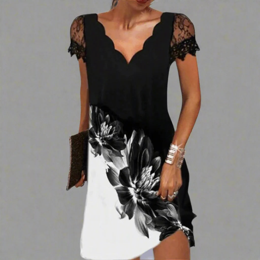 Frau in elegantem schwarz-weißem Kleid mit Blumenmuster und Spitzenärmeln, hält eine Clutch. Modetrend, Abendmode, stilvolles Design.