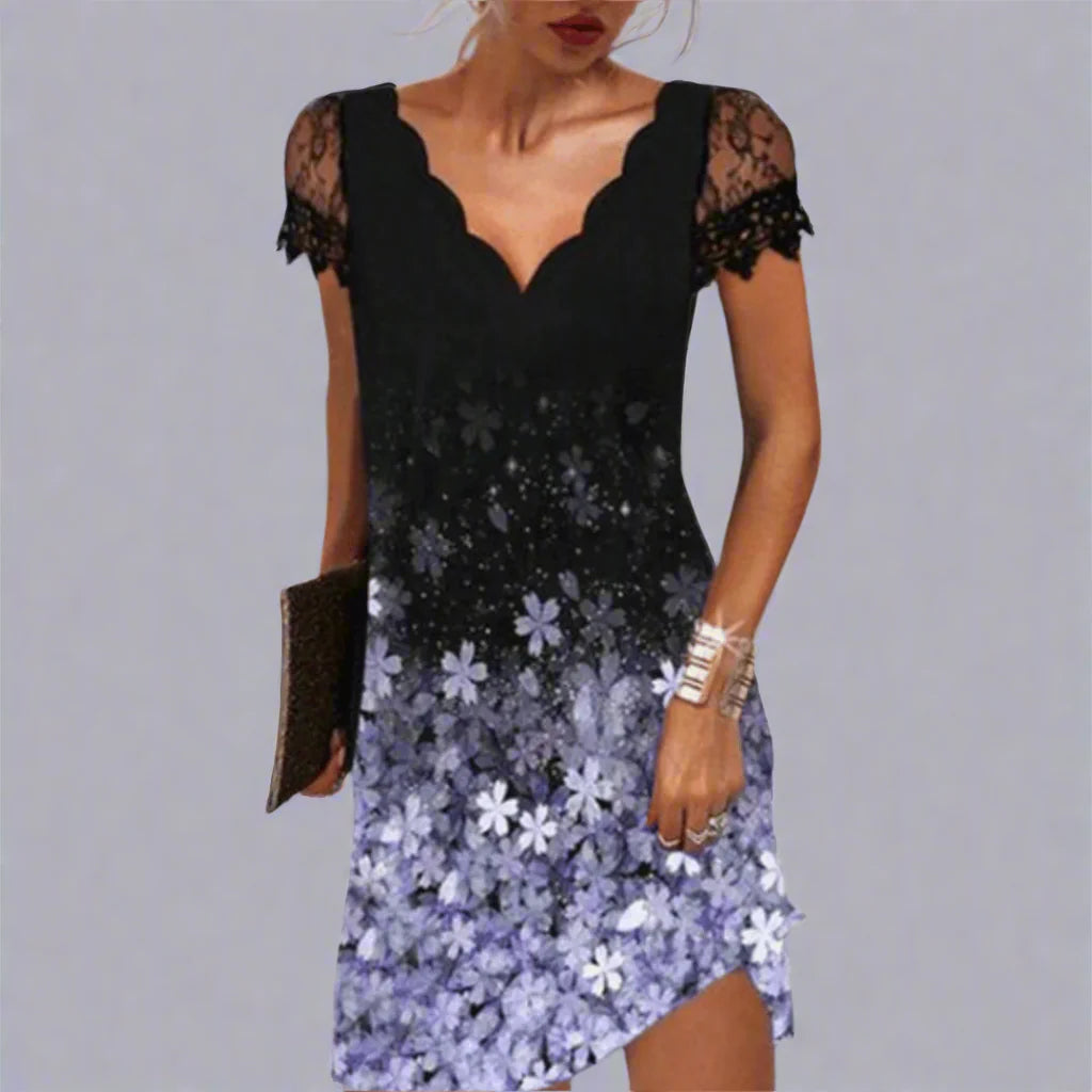 Schwarzes Kleid mit Spitzenärmeln und violettem Blumenmuster, asymmetrischer Saum, Frau hält Clutch, elegantes Abendoutfit.