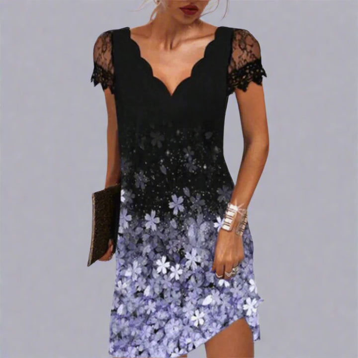 Schwarzes Kleid mit Spitzenärmeln und violettem Blumenmuster, asymmetrischer Saum, Frau hält Clutch, elegantes Abendoutfit.