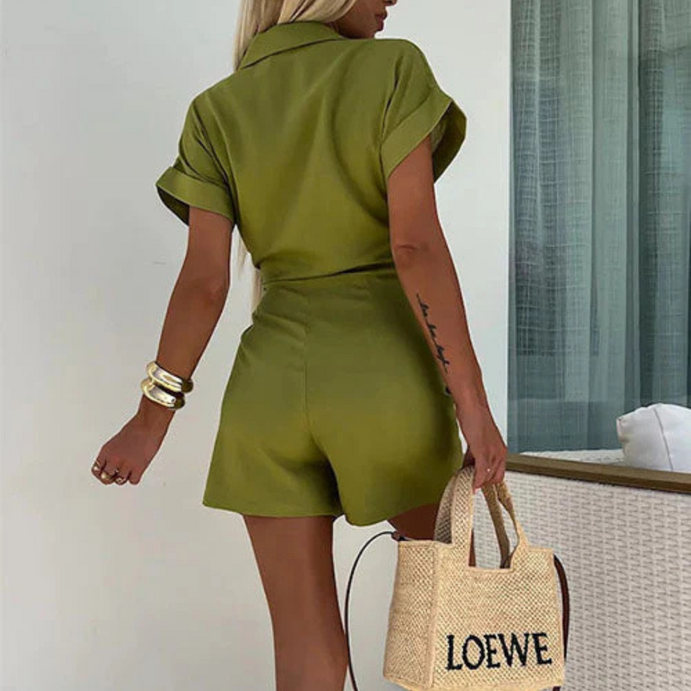 Frau in grünem Jumpsuit von hinten, hält eine Loewe Strohtasche. Sommermode, eleganter Look, trendige Damenbekleidung, stilvolle Accessoires.