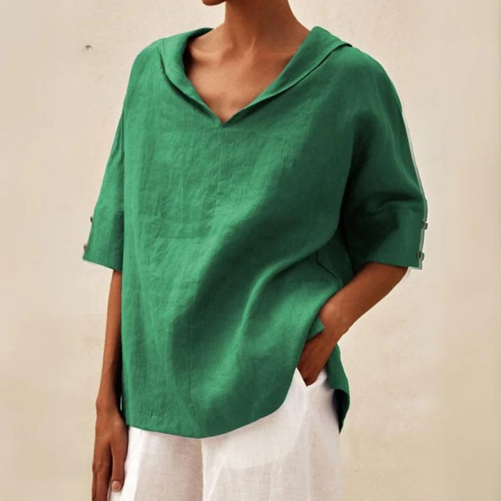 Grünes Leinenhemd mit V-Ausschnitt und 3/4-Ärmeln, lässiger Stil, kombiniert mit weißer Hose. Ideal für Sommermode und Freizeitkleidung.