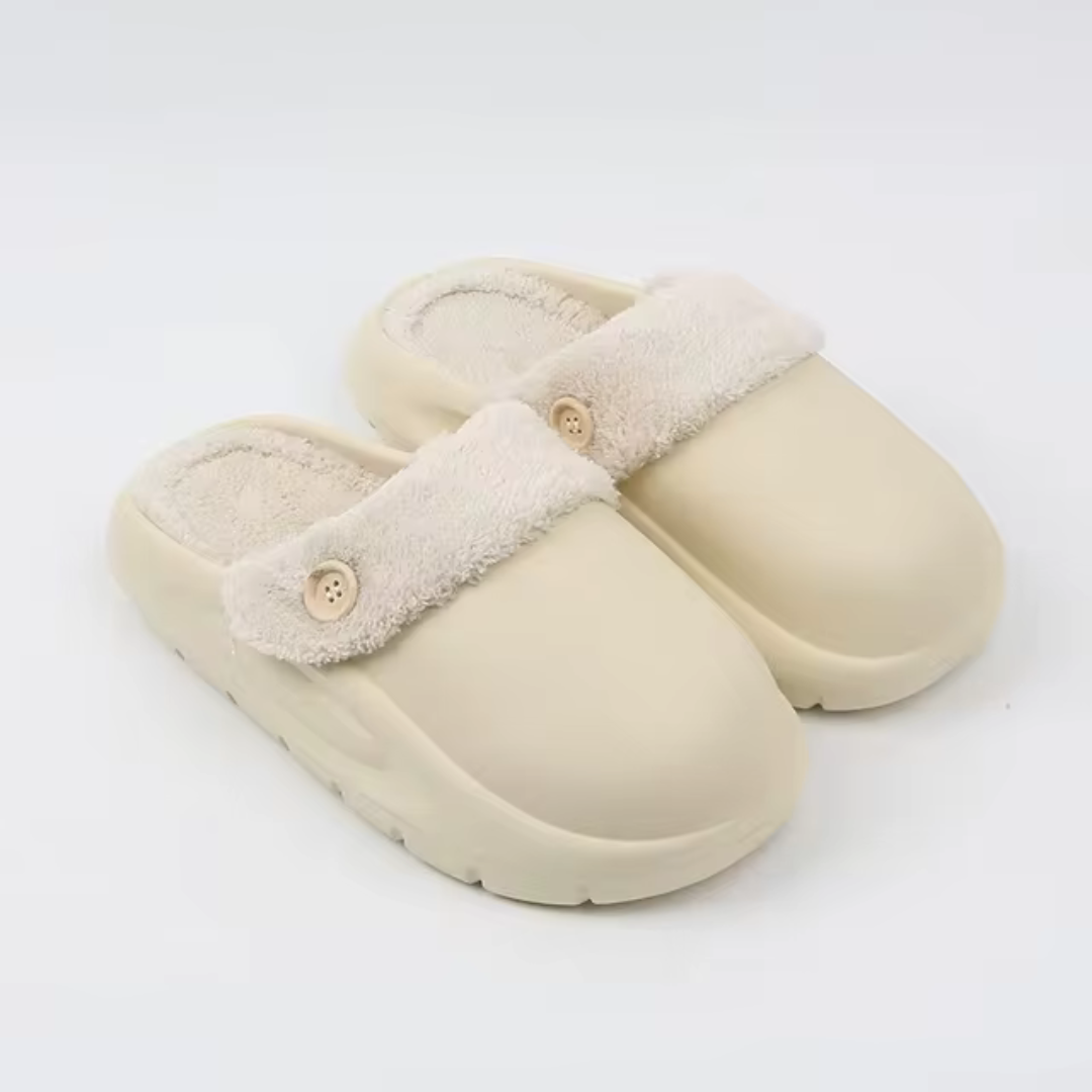 Beige Hausschuhe mit flauschigem Futter und Knopfdetail, rutschfeste Sohle, ideal für Komfort und Wärme im Winter. Perfekte Pantoffeln für Zuhause.