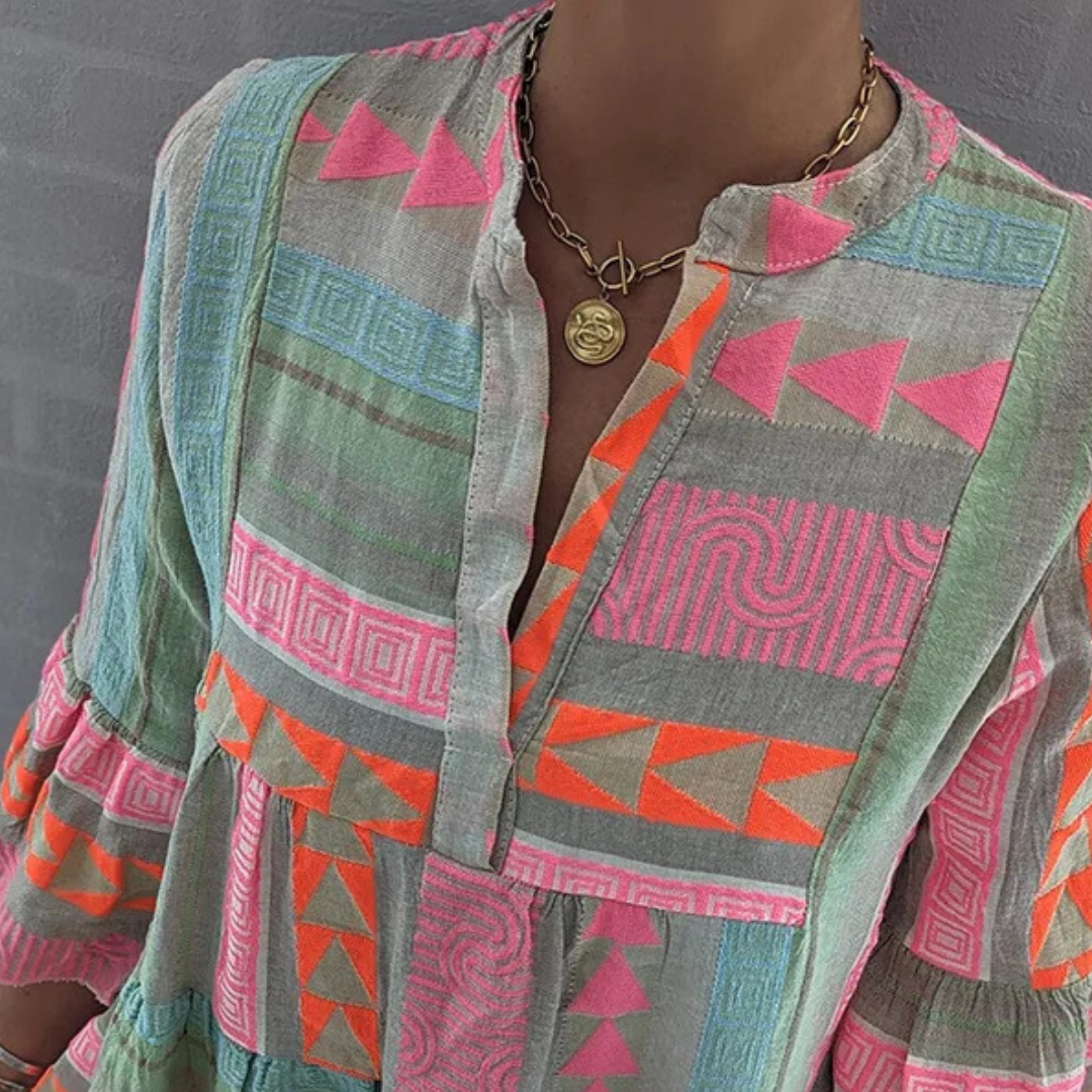 Bunte Boho-Bluse mit geometrischen Mustern in Pink, Orange und Grau, aus Leinenstoff. Perfekt für Sommermode und lässige Outfits.
