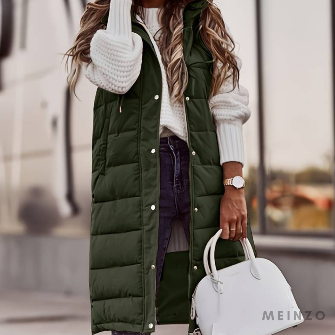 Frau in grüner Steppweste und weißem Pullover, hält weiße Handtasche. Modetrend Herbst, lässiger Streetstyle, stilvolle Damenmode.