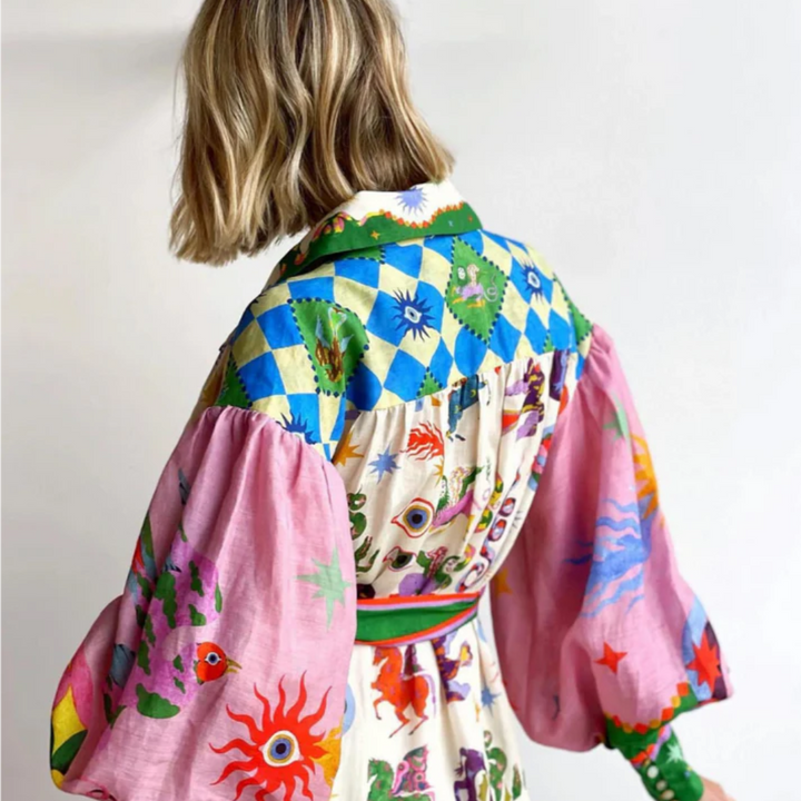 Frau in bunter, gemusterter Bluse mit Puffärmeln und Patchwork-Design, Rückansicht. Modetrend, farbenfrohe Kleidung, einzigartiger Stil.