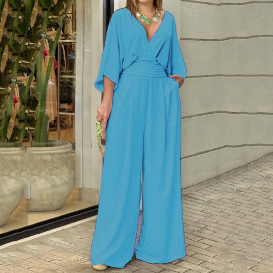 Frau in blauem Jumpsuit vor Geschäft, modisch, elegant, Sommermode, Damenbekleidung, stilvoll, trendig, Accessoires, Stadtbummel.