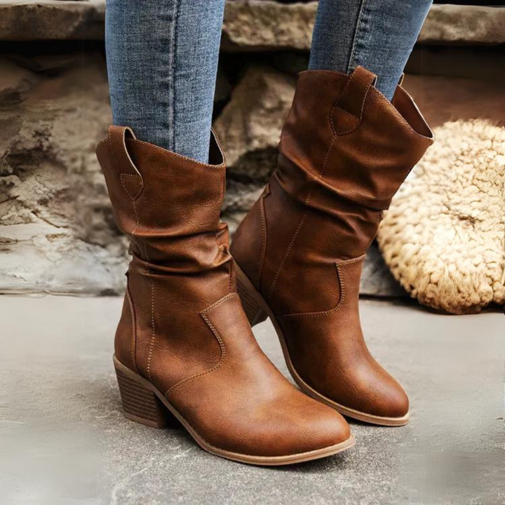 Braune Cowboystiefel aus Leder, getragen mit blauen Jeans. Modische Damenstiefel, ideal für Herbstmode und lässige Outfits.