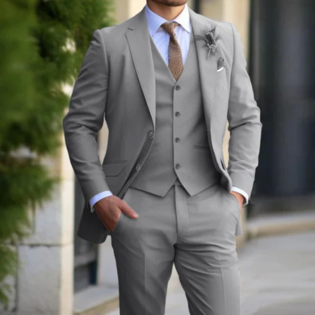 Eleganter Mann im grauen Anzug mit Weste und Krawatte, steht draußen. Businessmode, Herrenanzug, formelle Kleidung, stilvoller Look.