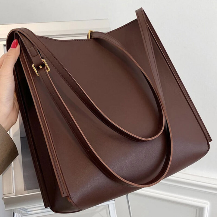 Dunkelbraune Ledertasche mit langen Henkeln, elegantes Design, modisches Accessoire, ideal für Damen, hochwertige Verarbeitung, stilvoll und praktisch.