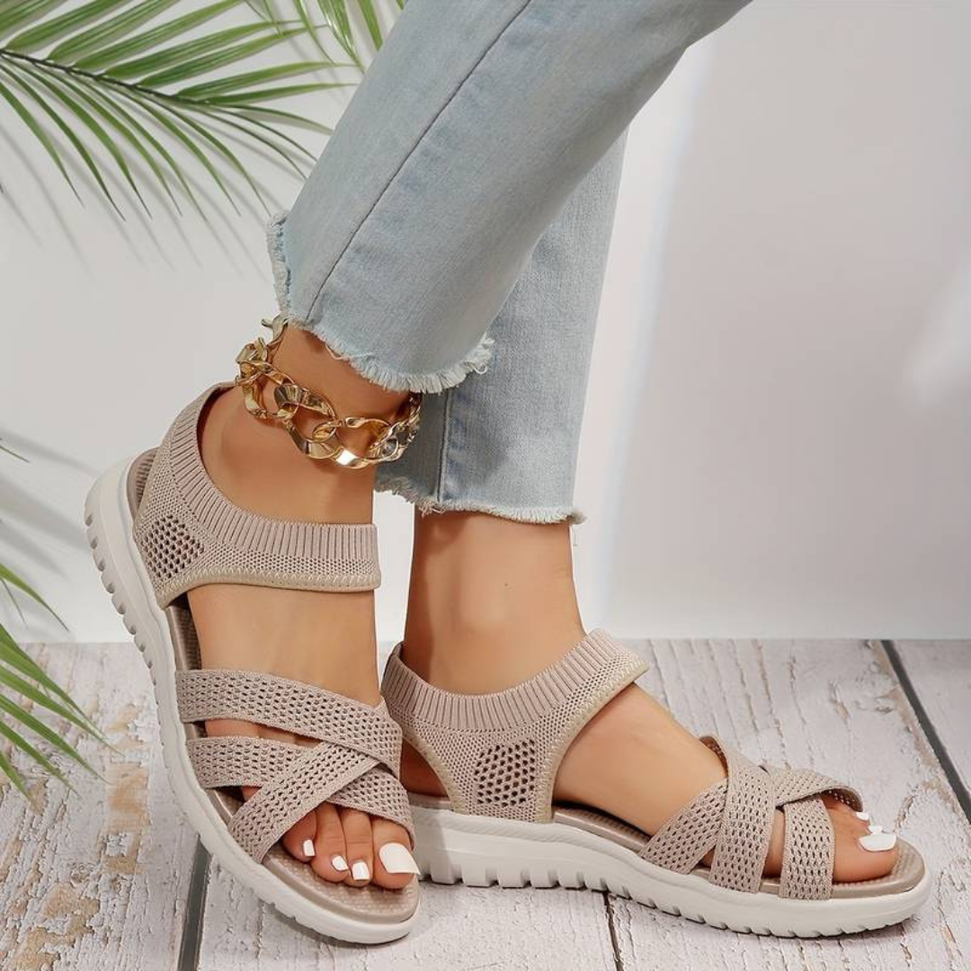 Beige Damen-Sandalen mit Strickdesign und weißer Sohle, getragen mit hellblauen Jeans. Sommermode, bequeme Schuhe, stilvolle Fußbekleidung.