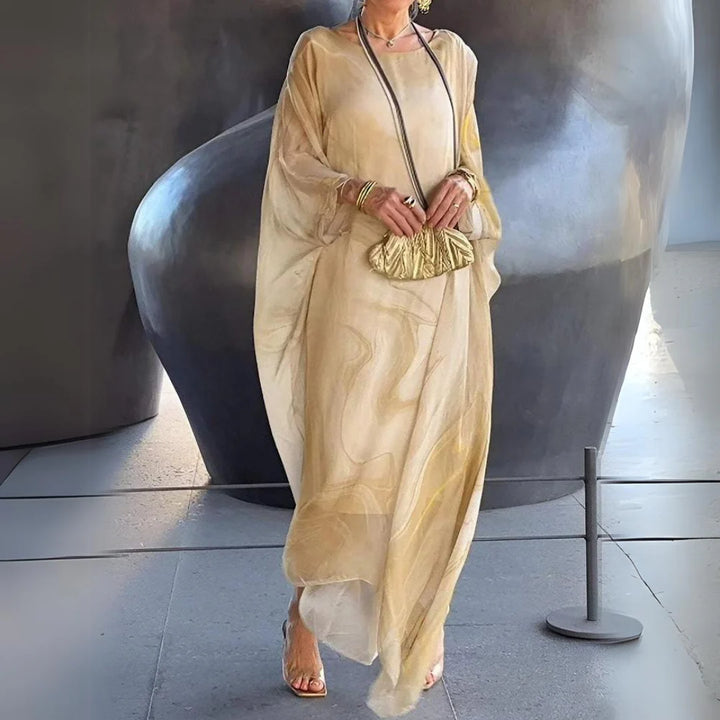 Elegante Frau in einem fließenden, goldenen Kaftan-Kleid mit passender Clutch, steht vor einer modernen, abstrakten Skulptur. Fashion, Stil, Kunst.