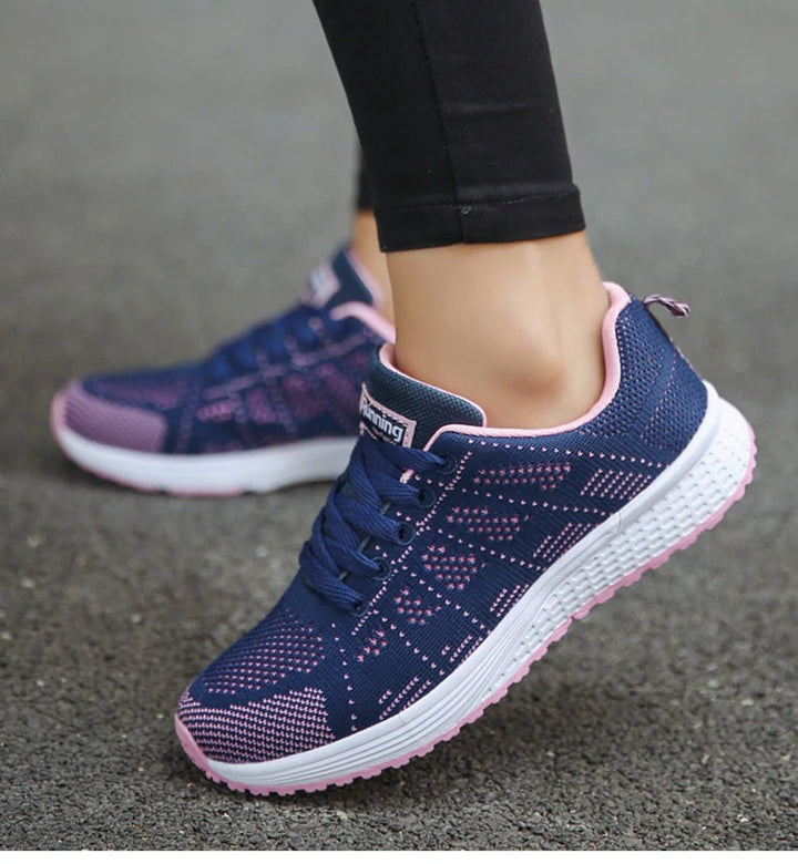 Damen-Laufschuhe in Blau und Rosa auf Asphalt, atmungsaktives Mesh-Design, ideal für Sport und Freizeit, bequeme Passform, rutschfeste Sohle.
