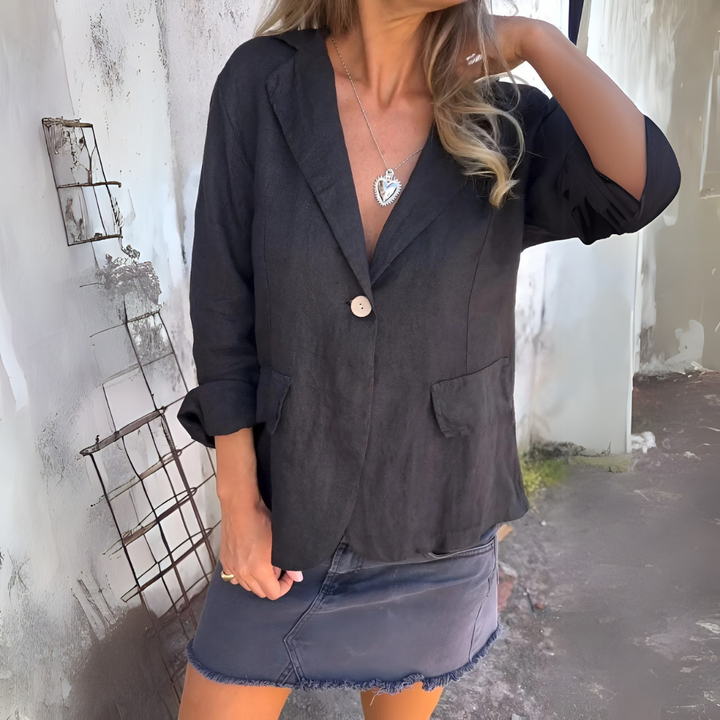 Frau in schwarzem Blazer und Jeansrock, trägt Herzanhänger-Halskette. Modetrend, lässiger Look, stilvolle Damenbekleidung, urbane Mode.