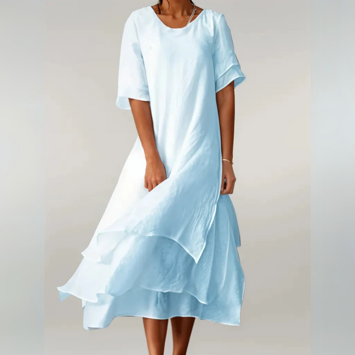Luftiges, hellblaues Sommerkleid aus Baumwolle, knielang, mit kurzen Ärmeln und fließendem Schnitt. Ideal für warme Tage und Strandspaziergänge.