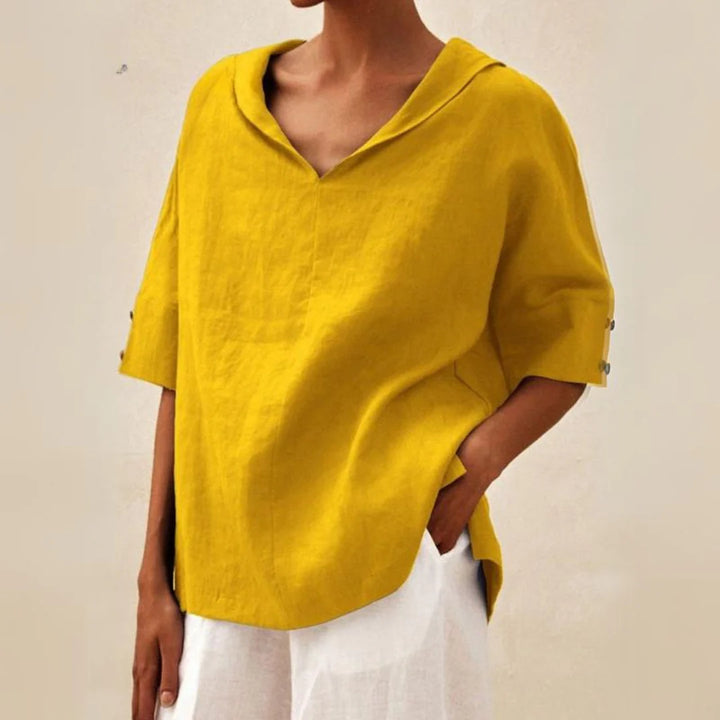 Gelbe Leinenbluse mit V-Ausschnitt und halblangen Ärmeln, kombiniert mit weißer Hose. Modetrend, Damenbekleidung, lässiger Sommerlook.