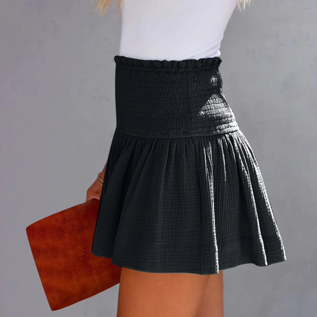 Frau in weißem Top und schwarzem Rock hält braune Clutch. Modetrend, Damenmode, Sommeroutfit, stilvoller Look.