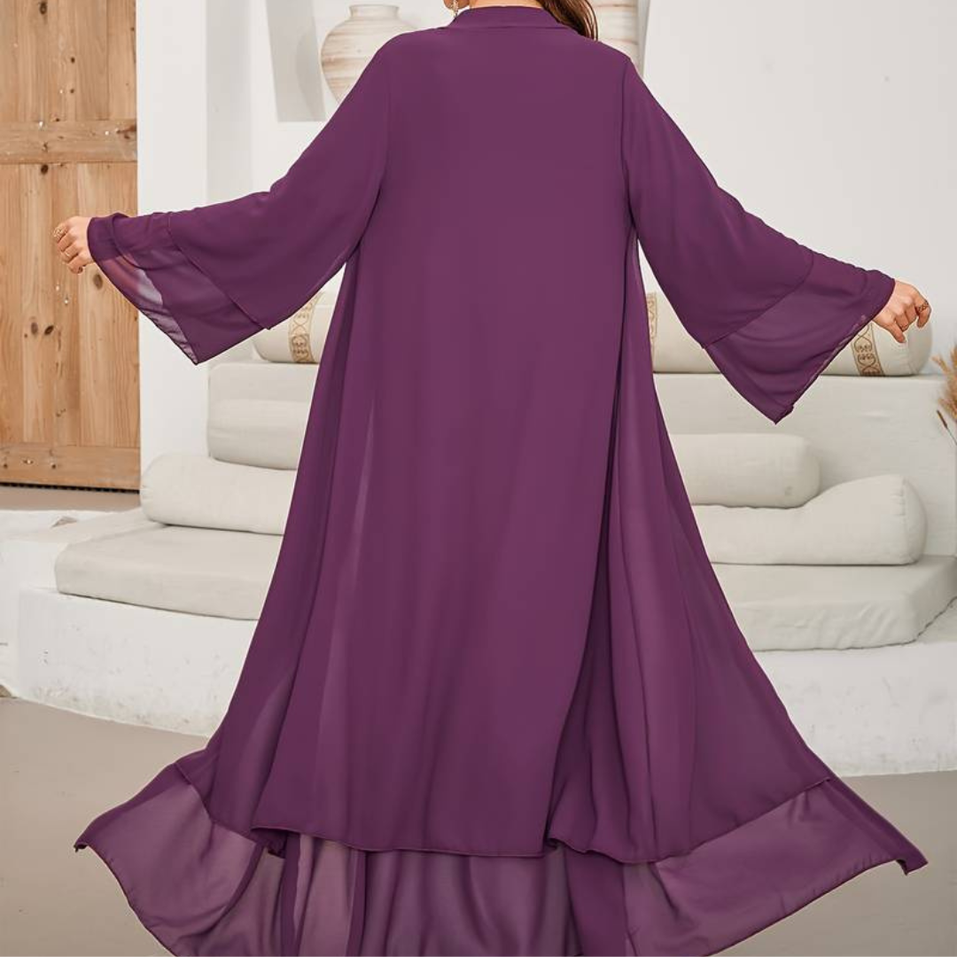 Frau in lila Maxikleid mit weiten Ärmeln, Rückenansicht. Elegantes, fließendes Design, ideal für Sommermode und festliche Anlässe.