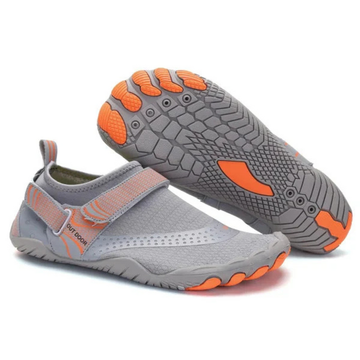 Graue Barfußschuhe mit orangefarbenen Sohlen, ideal für Outdoor-Aktivitäten. Leicht, atmungsaktiv und flexibel für natürlichen Laufkomfort.