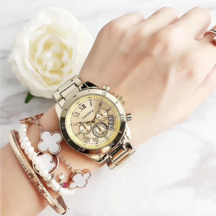 Goldene Damenarmbanduhr mit Chronographen auf Handgelenk, umgeben von eleganten Armbändern und weißer Rose im Hintergrund. Luxuriöse Accessoires.