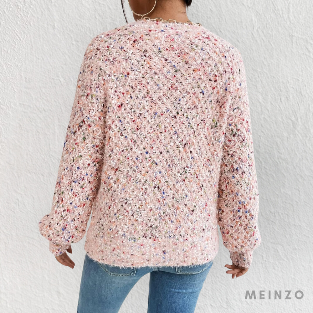 Rückansicht einer Frau in einem rosa Strickpullover mit buntem Muster, kombiniert mit blauen Jeans. Modetrend, Damenmode, Strickmode.