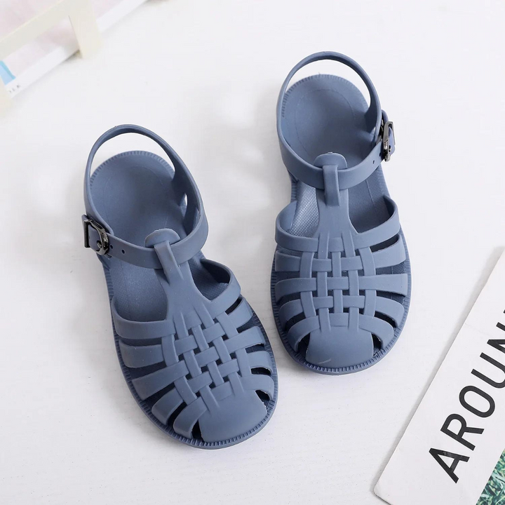 Blaue Sandalen aus Kunststoff mit Riemen und Schnalle auf weißem Hintergrund. Modische Sommerschuhe, ideal für Strand und Freizeit.