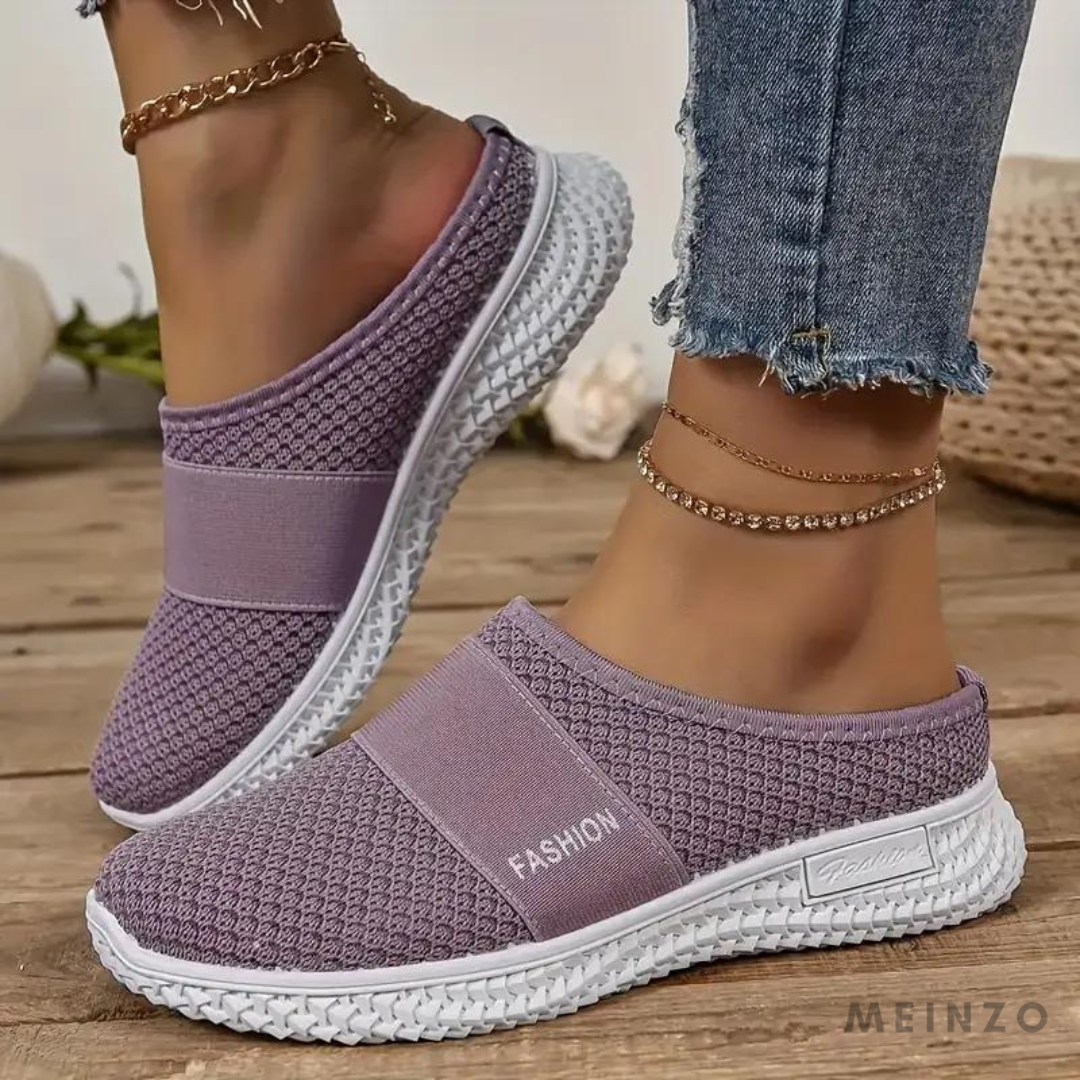 Lila Damen-Sneaker mit Strickmuster, weiße Sohle, lässig, bequem, modisch, ideal für Freizeit und Alltag, getragen mit Jeans und Fußkettchen.