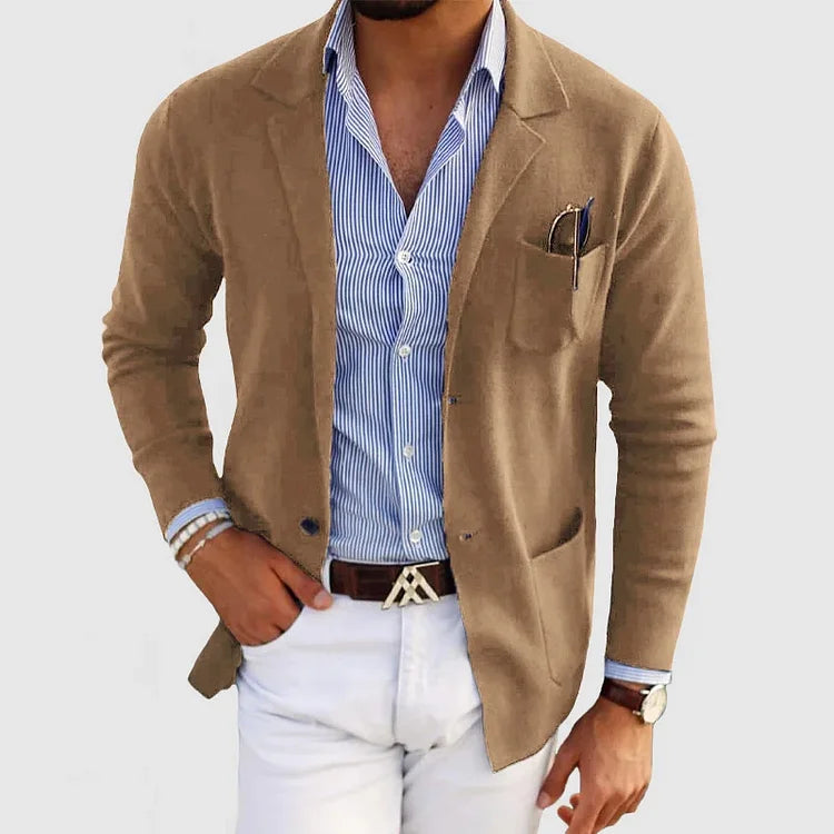 Mann in braunem Blazer, blau-weiß gestreiftem Hemd und weißer Hose. Eleganter, moderner Herrenstil, ideal für Business-Casual-Outfits.