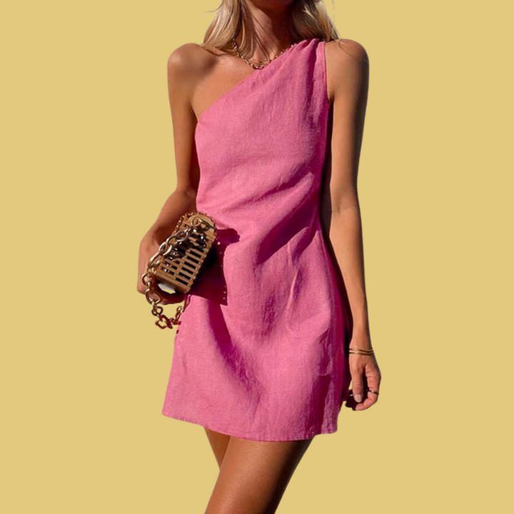Frau in einem schulterfreien, pinken Sommerkleid mit goldener Handtasche vor gelbem Hintergrund. Elegantes, modisches Outfit für den Sommer.