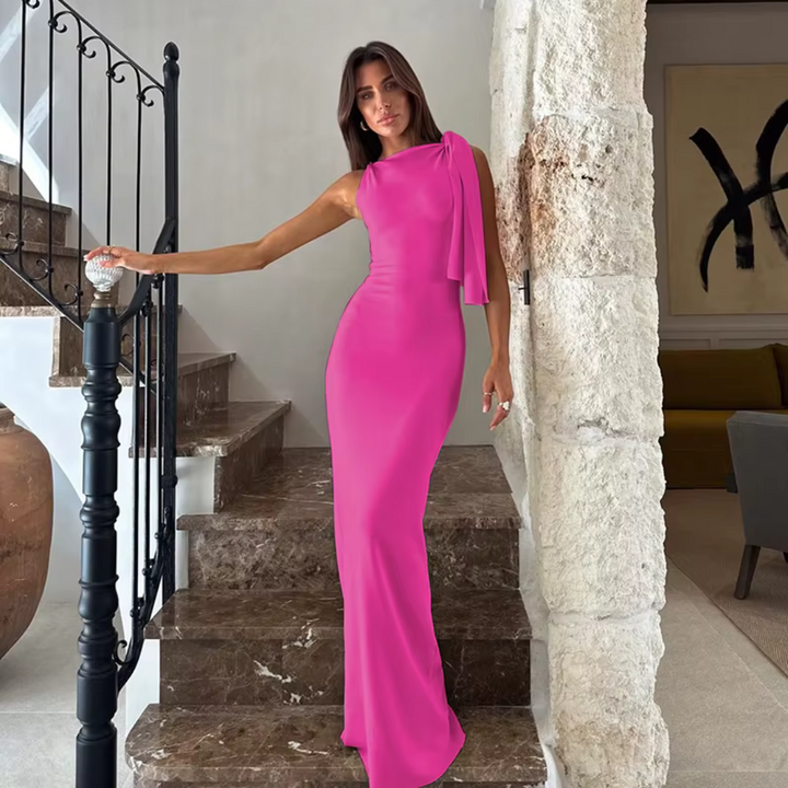 Eine Frau in einem eleganten, pinken Abendkleid steht auf einer Marmortreppe. Stilvolle Mode, Abendgarderobe, luxuriöses Design.