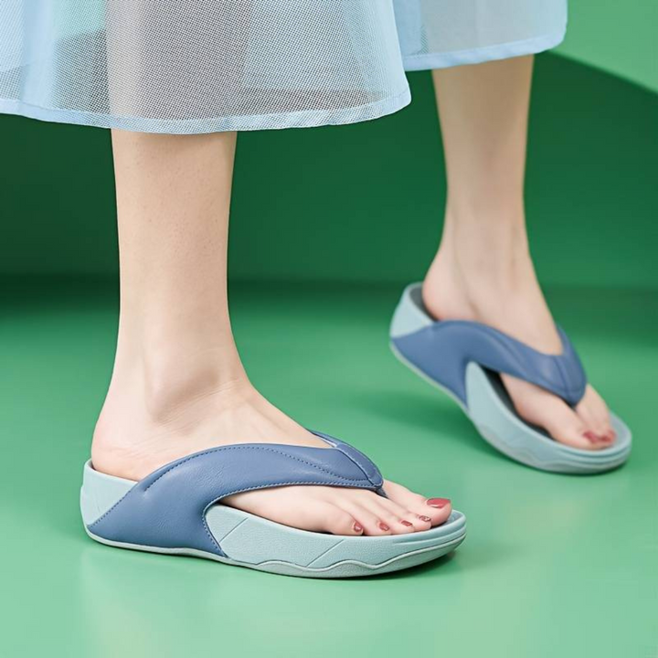 Damen tragen blaue orthopädische Sandalen auf grünem Hintergrund. Bequeme, ergonomische Sommerschuhe für gesunde Füße und optimalen Tragekomfort.