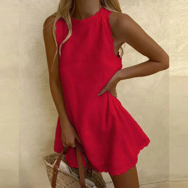 Frau in rotem Sommerkleid mit Wellensaum, hält eine Strohtasche. Modetrend 2023, elegantes Freizeitoutfit, ideal für warme Tage.