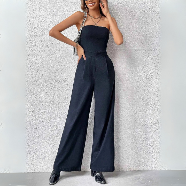 Eleganter schwarzer Jumpsuit für Damen, ärmellos und mit weitem Bein, kombiniert mit schwarzen Stiefeletten. Perfekt für stilvolle Anlässe.