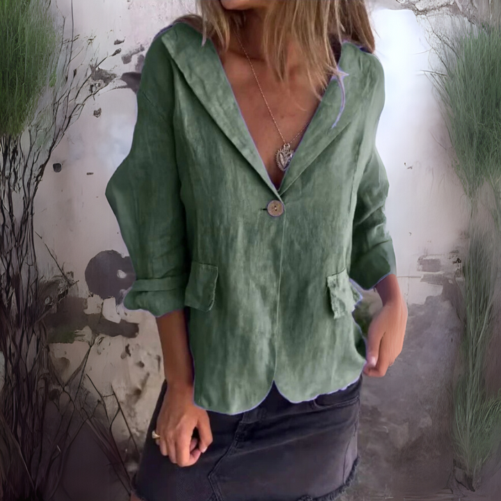 Frau in grünem Leinenblazer und schwarzem Rock vor rustikalem Hintergrund. Modetrend, Damenbekleidung, lässiger Stil, Herbstmode.