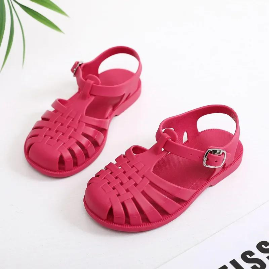 Rote Kindersandalen aus Kunststoff mit verstellbarem Riemen, ideal für Sommer und Strand. Bequeme, atmungsaktive Schuhe für Kinder.