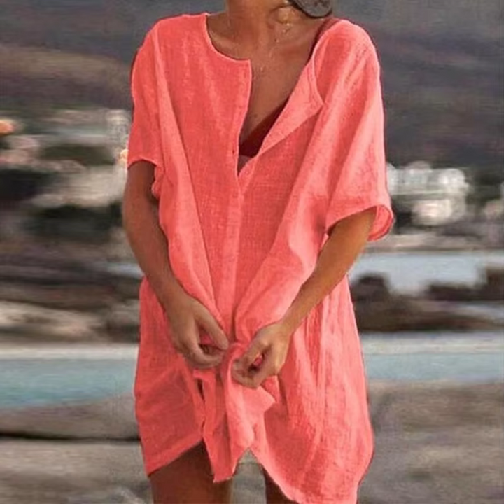 Frau in rosa Leinenkleid am Strand, Sommermode, lässiger Stil, Urlaubskleidung, entspannte Atmosphäre, Strandhintergrund, Freizeitlook.