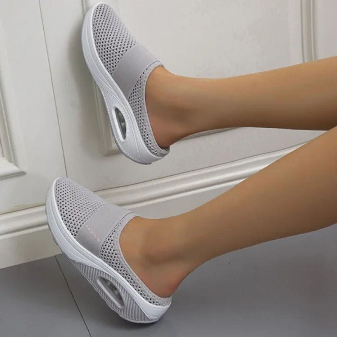 Graue atmungsaktive Damen-Sneaker mit Mesh-Oberfläche und weißer Sohle, bequemes Design, ideal für Freizeit und Sport.