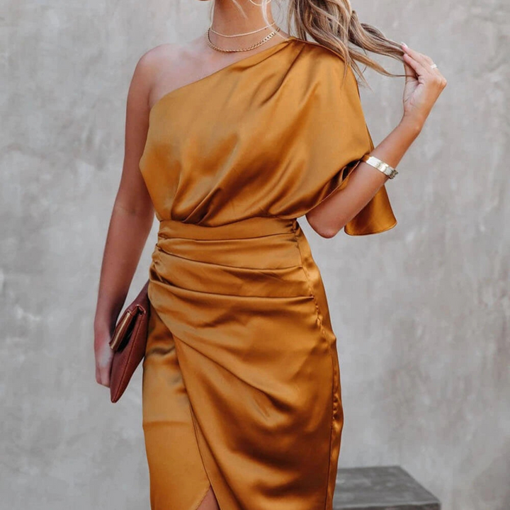 Frau in eleganter, einseitiger, goldener Satinkleid, hält eine Clutch. Perfekt für Abendmode, Cocktailpartys, stilvolle Mode.