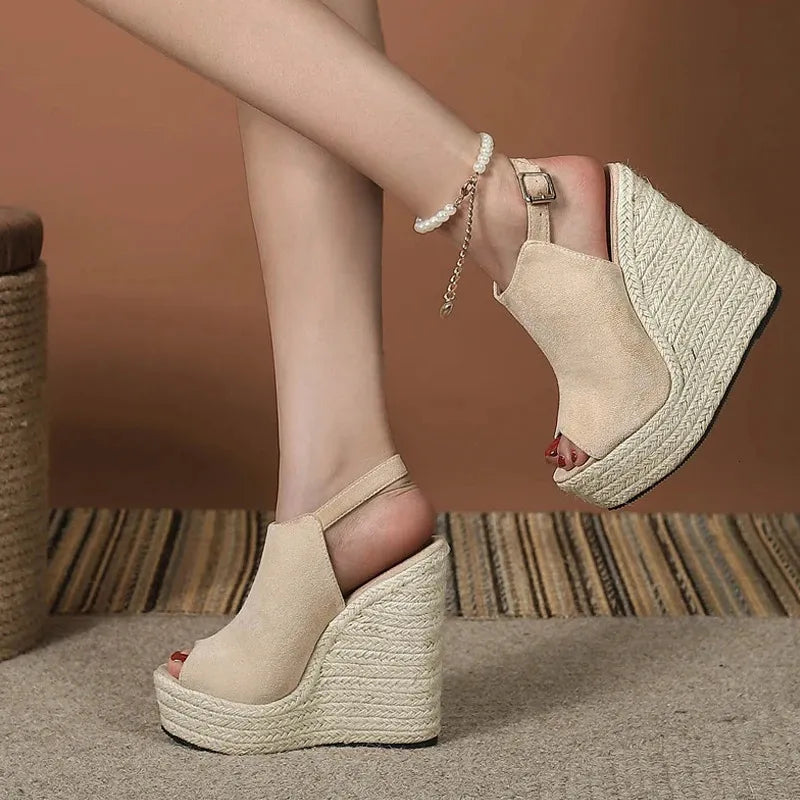 Beige Damen-Wedges mit Plateau, offener Zehenpartie und Knöchelriemen auf gestreiftem Teppich. Modische Sommerschuhe, ideal für elegante Outfits.
