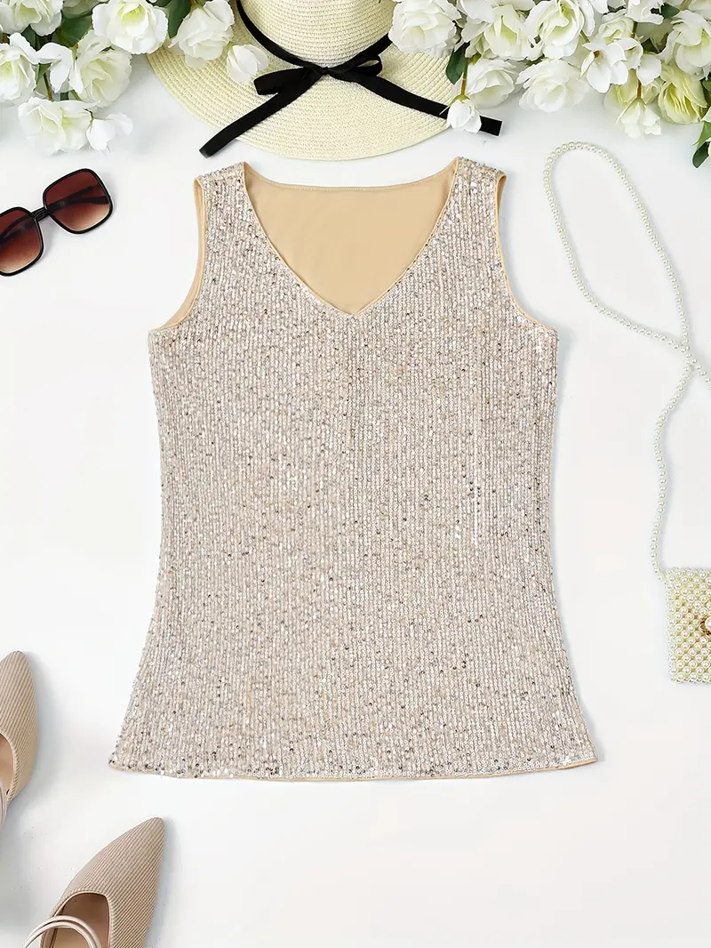 Ärmelloses, glitzerndes Paillettentop in Beige auf weißem Hintergrund, umgeben von Sonnenhut, Sonnenbrille, Blumen, Handtasche und Schuhen.