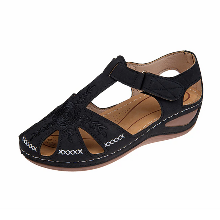 Schwarzer Damen-Sommerschuh mit Blumenstickerei, Klettverschluss und Keilabsatz. Bequem, atmungsaktiv, ideal für Freizeit und Alltag.