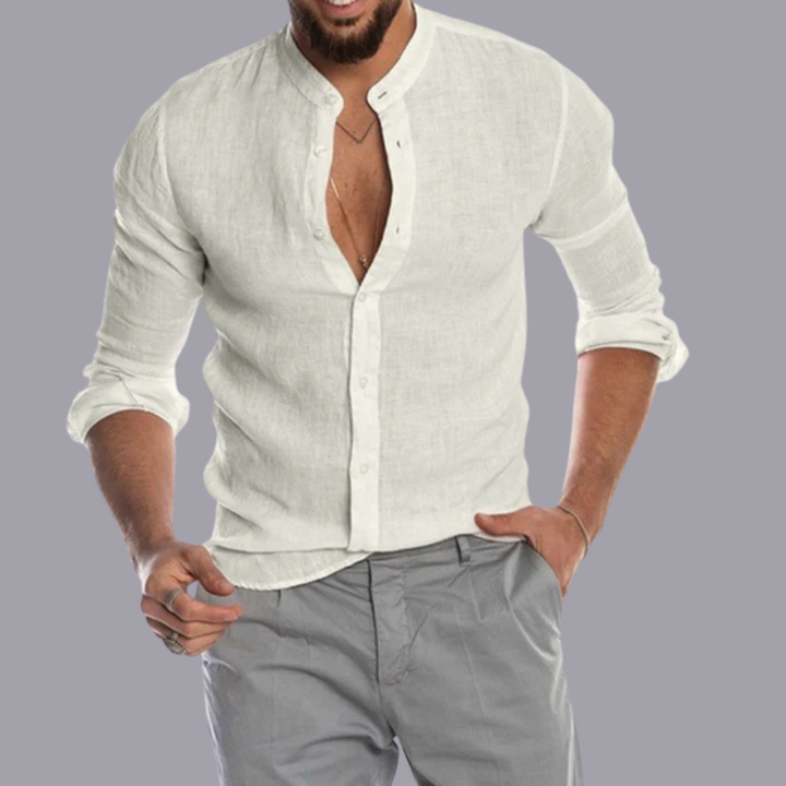 Mann in weißem Leinenhemd mit Stehkragen und grauer Hose, lässiger Stil, Mode für Herren, elegantes Freizeitoutfit, grauer Hintergrund.