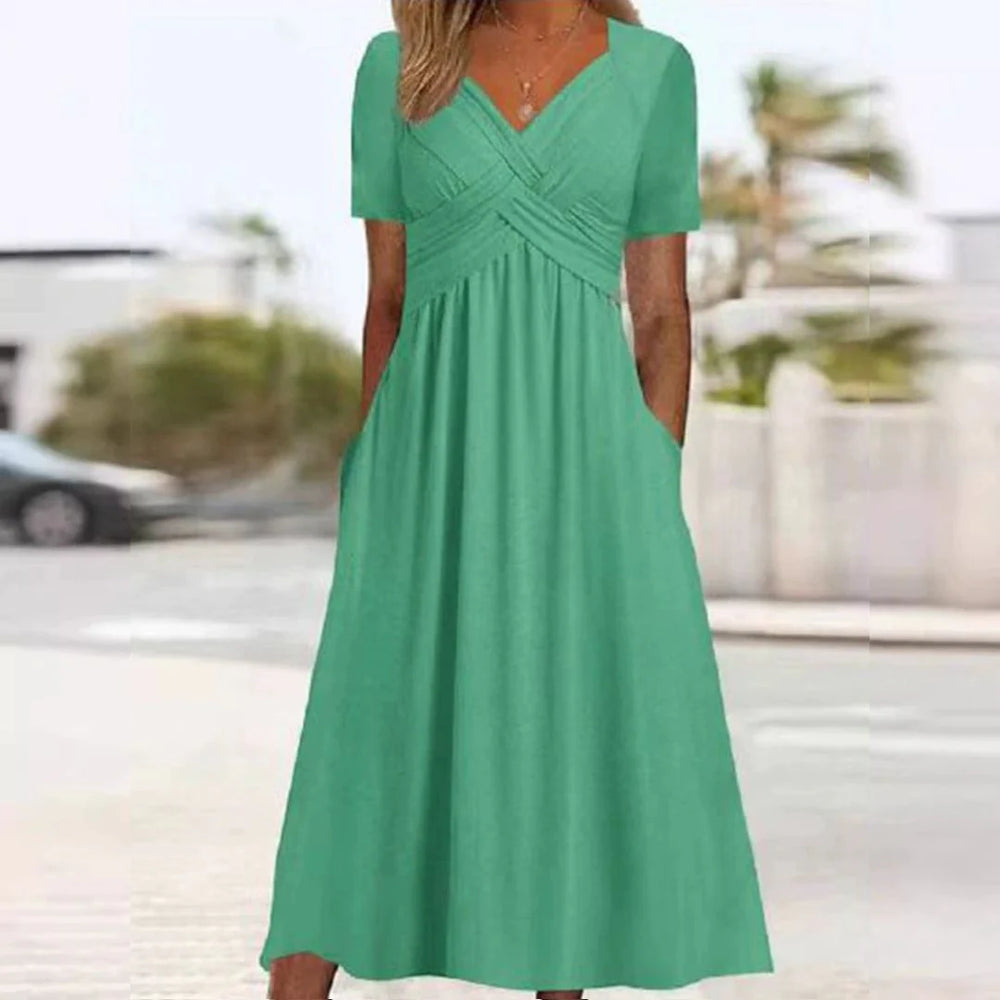 Grünes Sommerkleid mit kurzen Ärmeln und V-Ausschnitt, knielang, aus leichtem Stoff, ideal für Freizeit und Strand, modisch und bequem.
