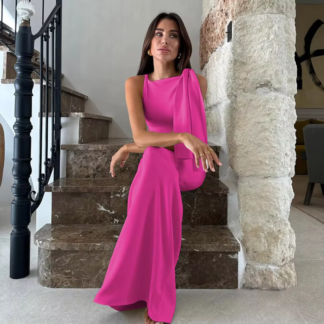 Frau in elegantem, pinkem Abendkleid sitzt auf Marmortreppe, moderne Inneneinrichtung, stilvolle Mode, luxuriöses Design, zeitgenössischer Stil.