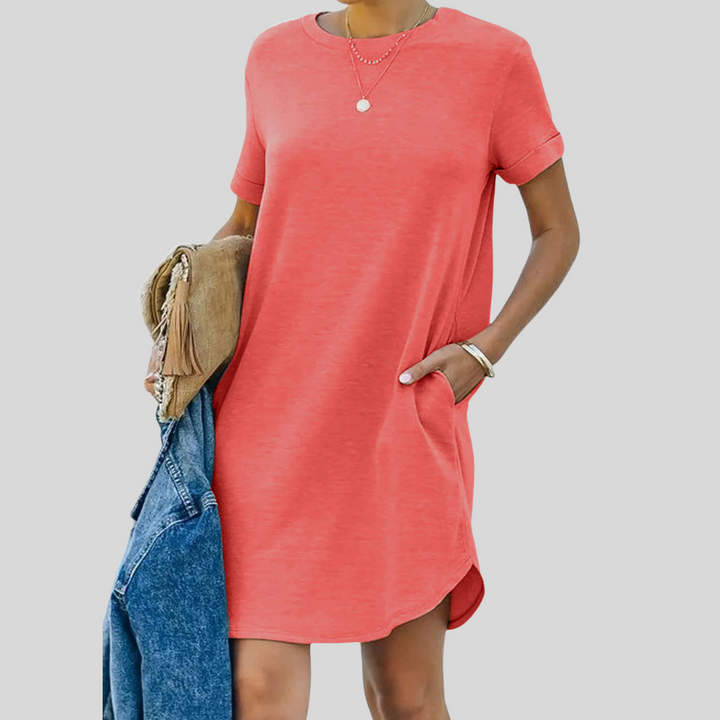 Frau in rotem T-Shirt-Kleid mit Taschen, hält eine Jeansjacke und eine braune Tasche. Modetrend, lässiger Stil, Sommeroutfit.