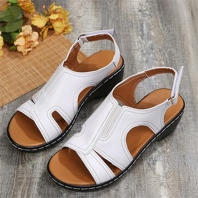Weiße Damen-Sandalen mit Keilabsatz auf Holzboden, modisches Design, bequem, ideal für Sommer, neben gelben Blumen.