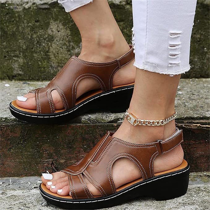 Braune Damen-Sandalen mit Keilabsatz und Cut-Out-Design, getragen mit weißen, zerrissenen Jeans. Perfekt für Sommermode und bequemen Stil.