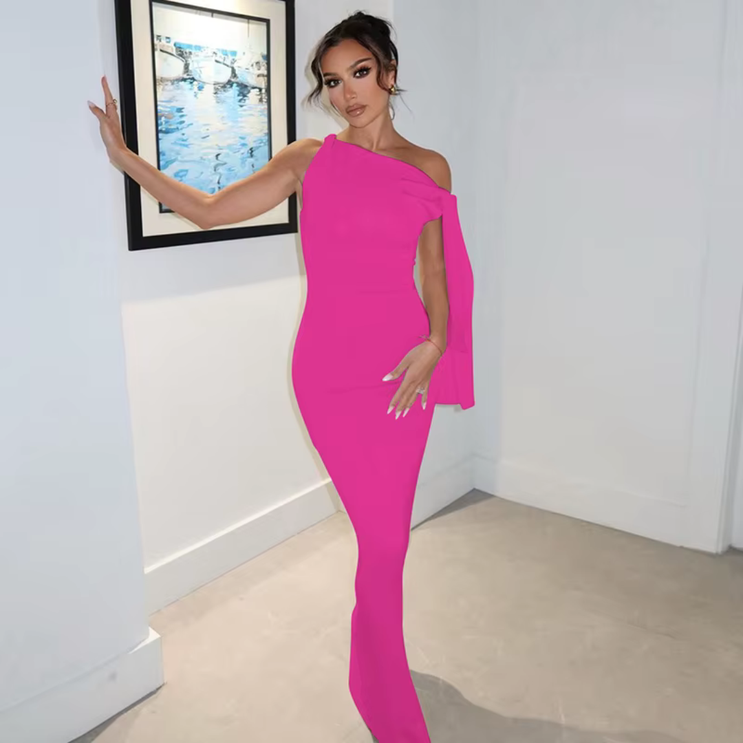 Elegante Frau in einem leuchtend pinken, schulterfreien Kleid posiert vor einem gerahmten Bild an einer weißen Wand. Fashion, Abendmode, Stil.