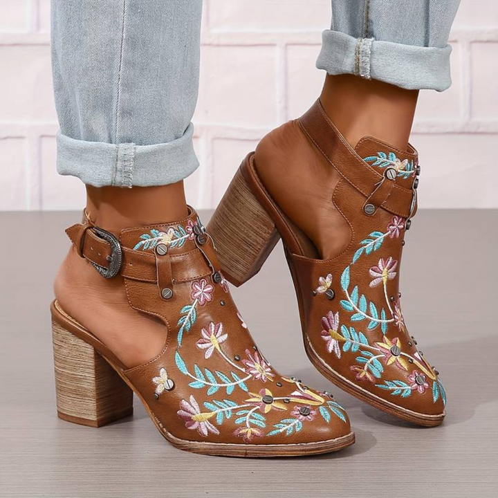 Braune Lederstiefeletten mit bunten Blumenstickereien, Blockabsatz und Schnallenverschluss. Modische Damenstiefel, ideal für den Herbst.