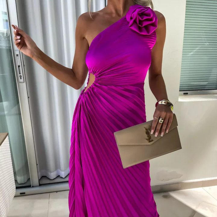 Frau in einem eleganten, einseitigen, fuchsiafarbenen Abendkleid mit Rüschen und goldener Clutch. Perfekt für formelle Anlässe und Partys.