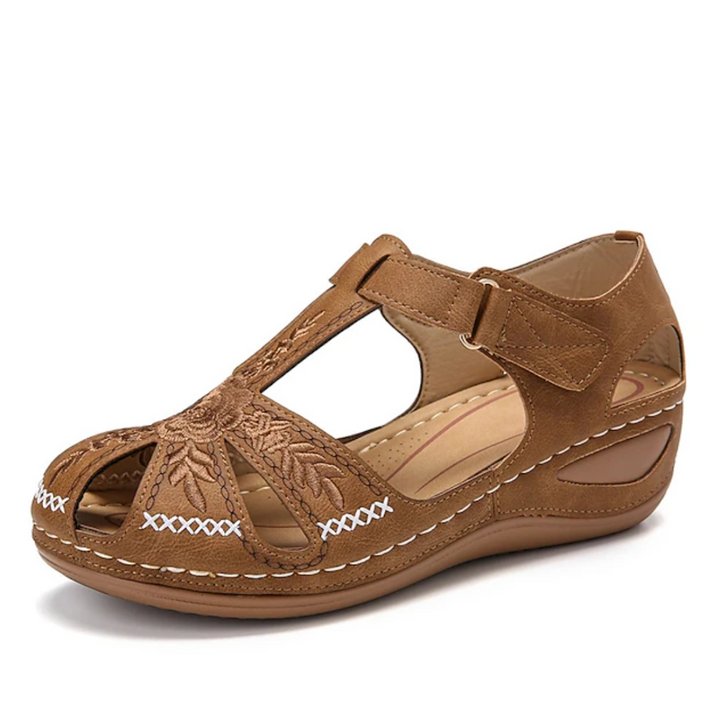 Braune Damen-Sandale mit Blumenstickerei, Klettverschluss und Keilabsatz. Bequemes Design, ideal für Sommermode und Freizeitkleidung.
